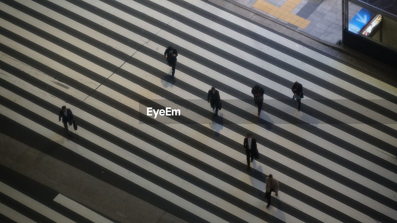 High angle view of people crossing road on a large zebra crossing in tokyo