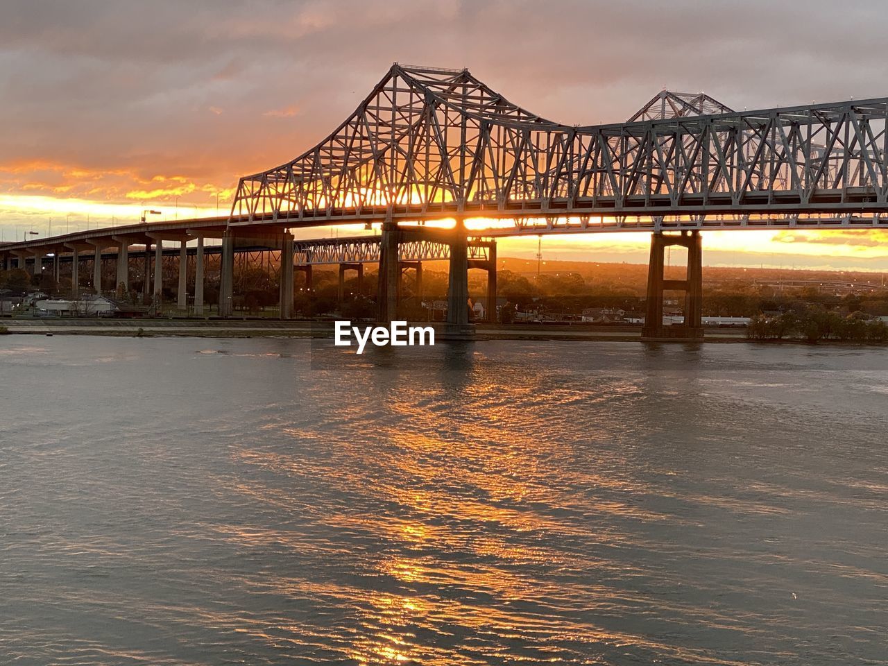 Bridge over river against sky during sunset