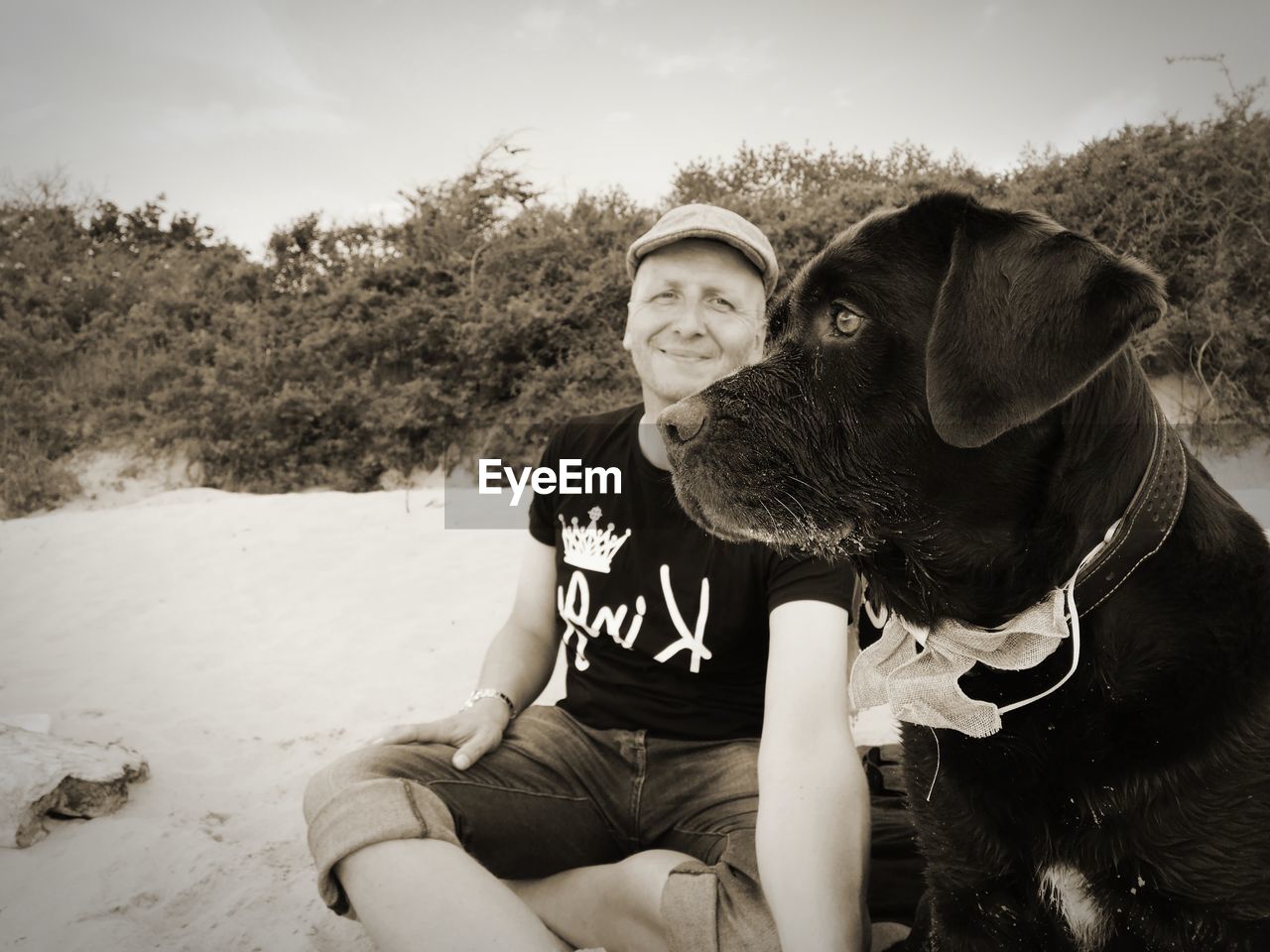 Young man with dog sitting on land