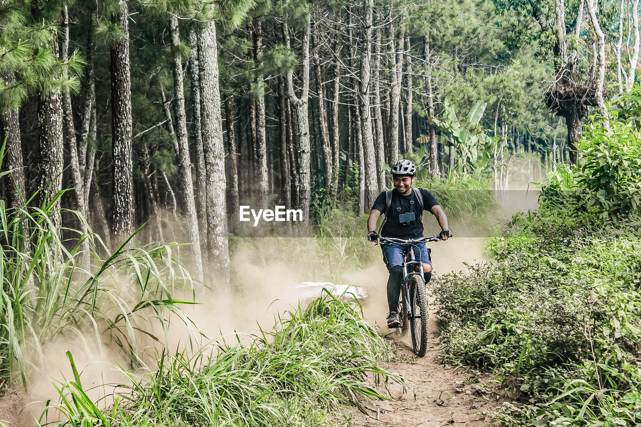 Man riding bicycle in forest