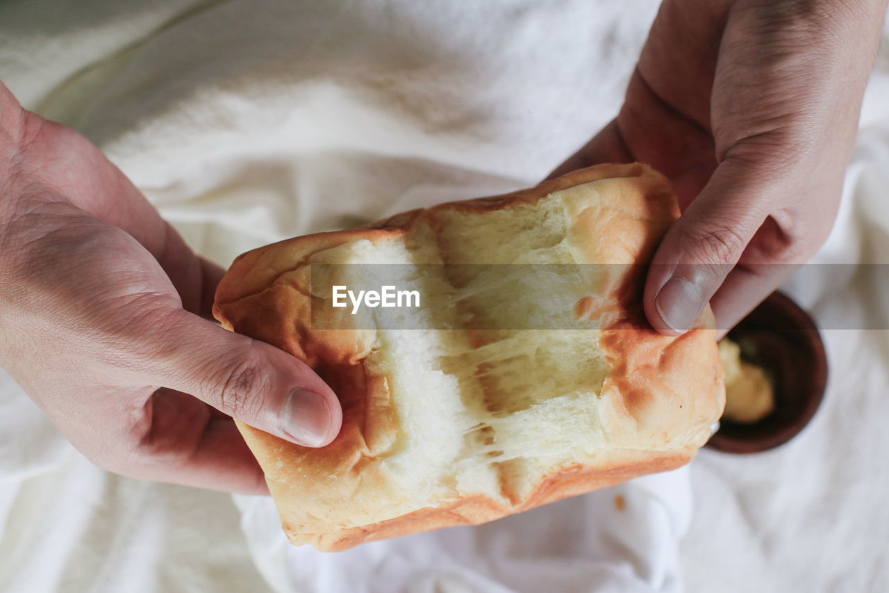 cropped hand of person holding bread