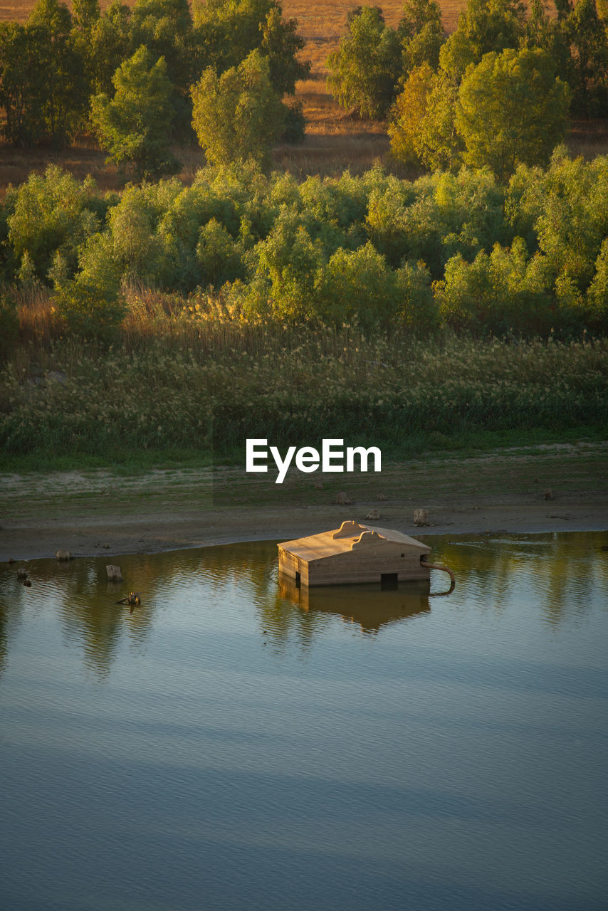 Wooden fishermen house inside water on guadiana river between spain and portugal with beautiful tree