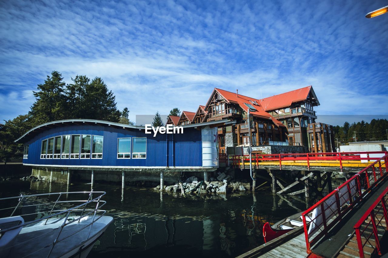 BUILT STRUCTURE BY RIVER AGAINST BUILDINGS