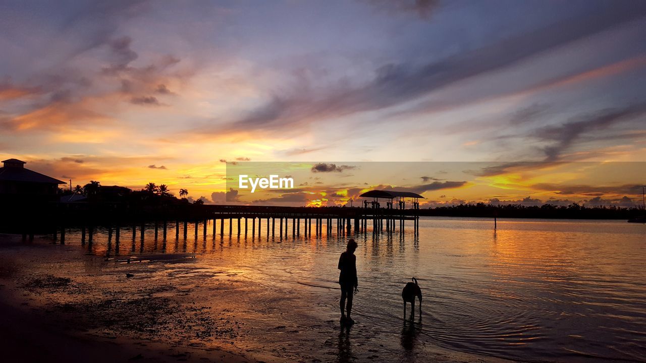 SCENIC VIEW OF LAKE AGAINST ORANGE SKY DURING SUNSET