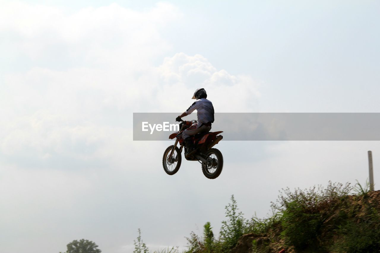 real people, motorcycle, crash helmet, one person, helmet, men, adventure, outdoors, full length, day, extreme sports, motocross, risk, sports race, sky, headwear, sports helmet, sport, competitive sport, nature, biker, people