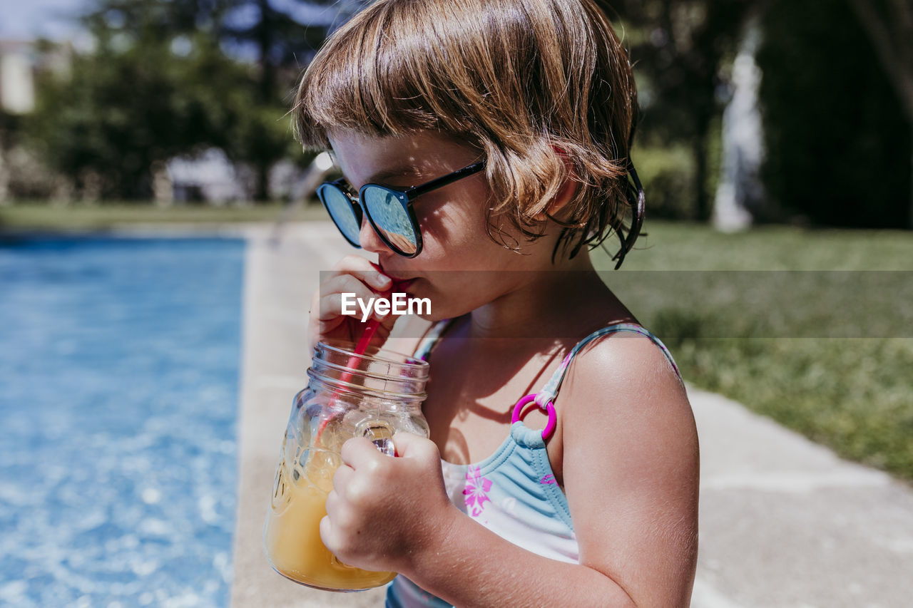 PORTRAIT OF GIRL DRINKING WATER IN PARK