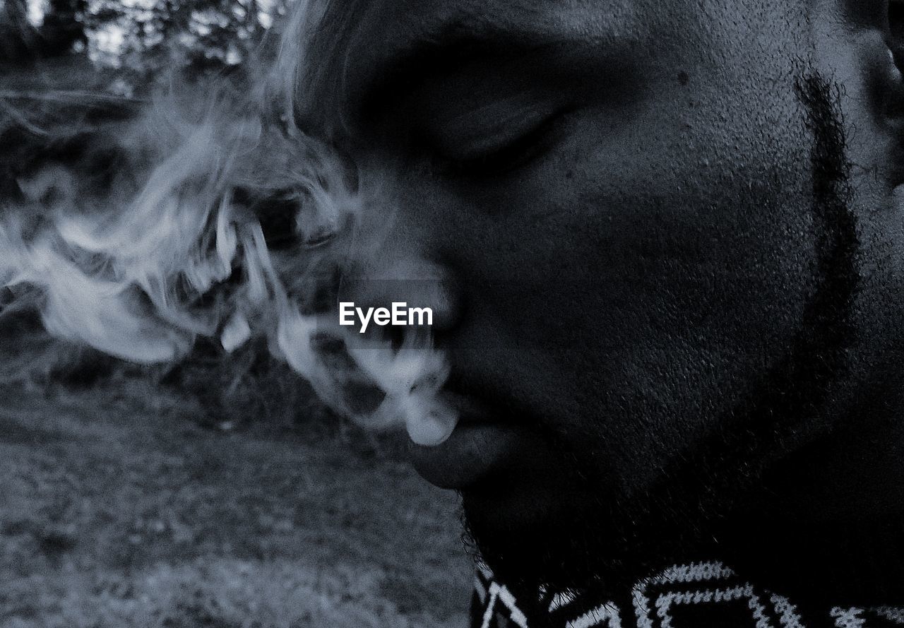 Close-up of man emitting smoke