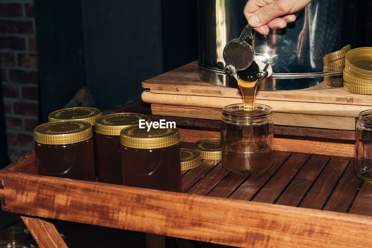 cropped hand of man preparing food in container on table