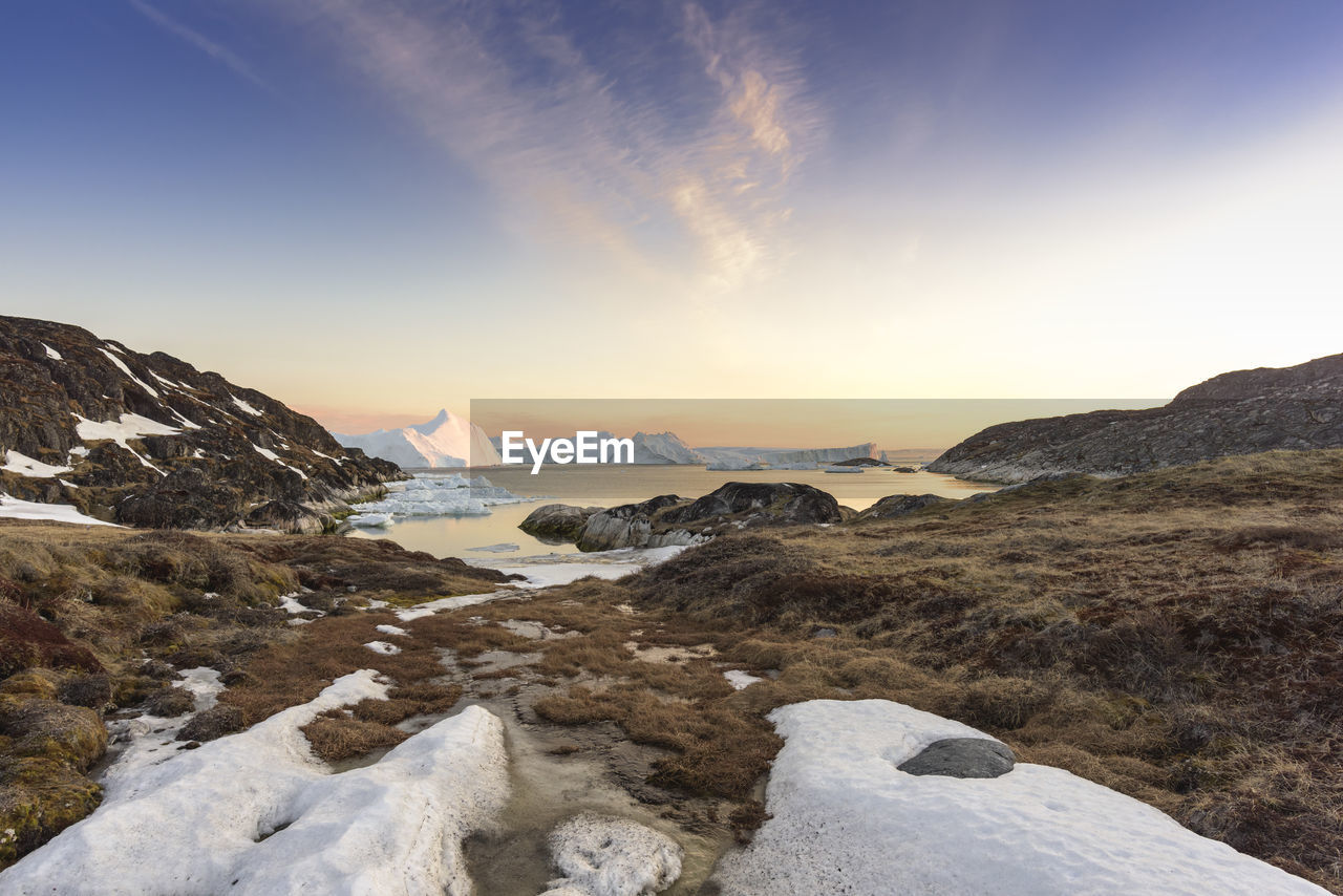 Scenic view of snowcapped mountains against sky during sunset