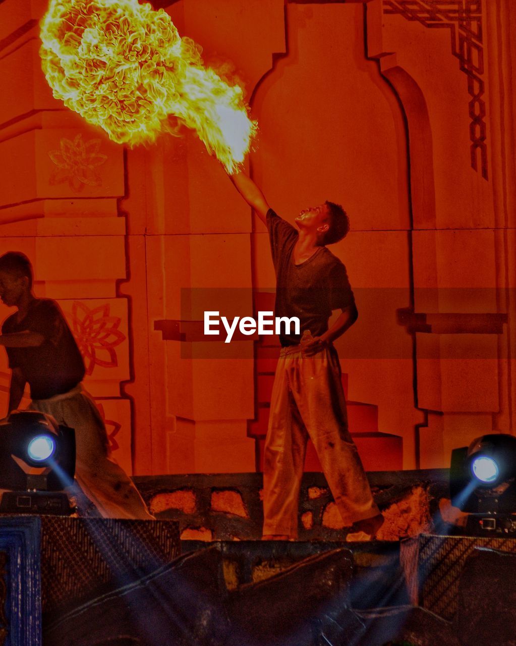 Men performing stunt with fire on stage