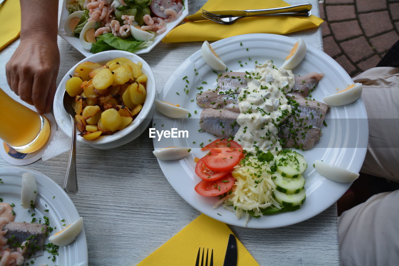 Sea food with salad and prepared potatoes served on table