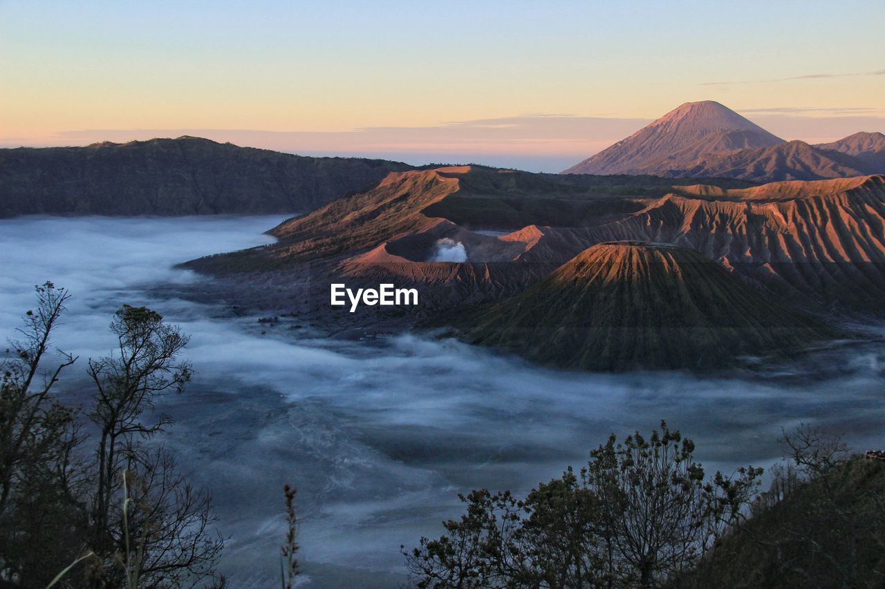 Panoramic view of arid landscape against sky during sunset. mount bromo national park