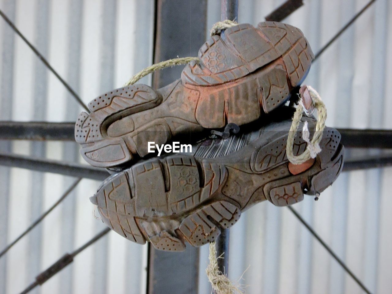 Close-up of shoes on railing against wall