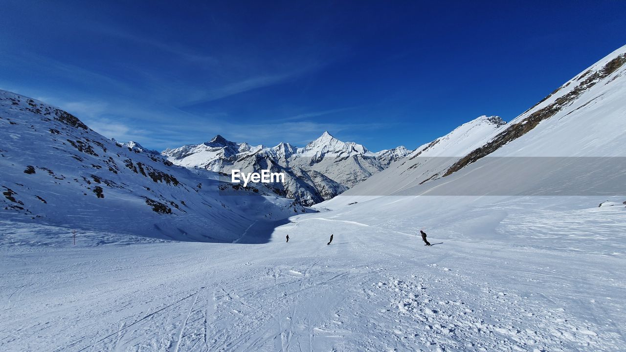 SNOW COVERED MOUNTAIN AGAINST BLUE SKY