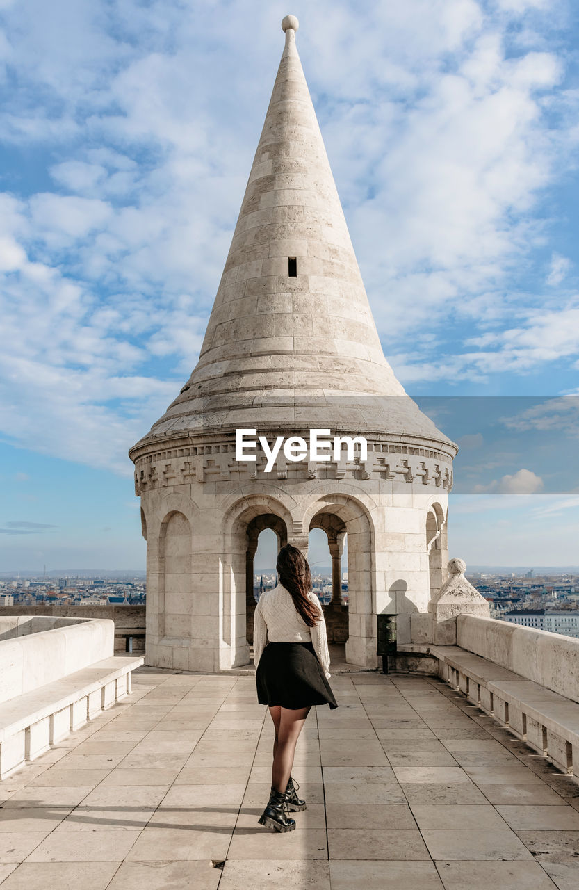 Girl standing on walls in front of spire at fisherman's bastion in budapest, hungary