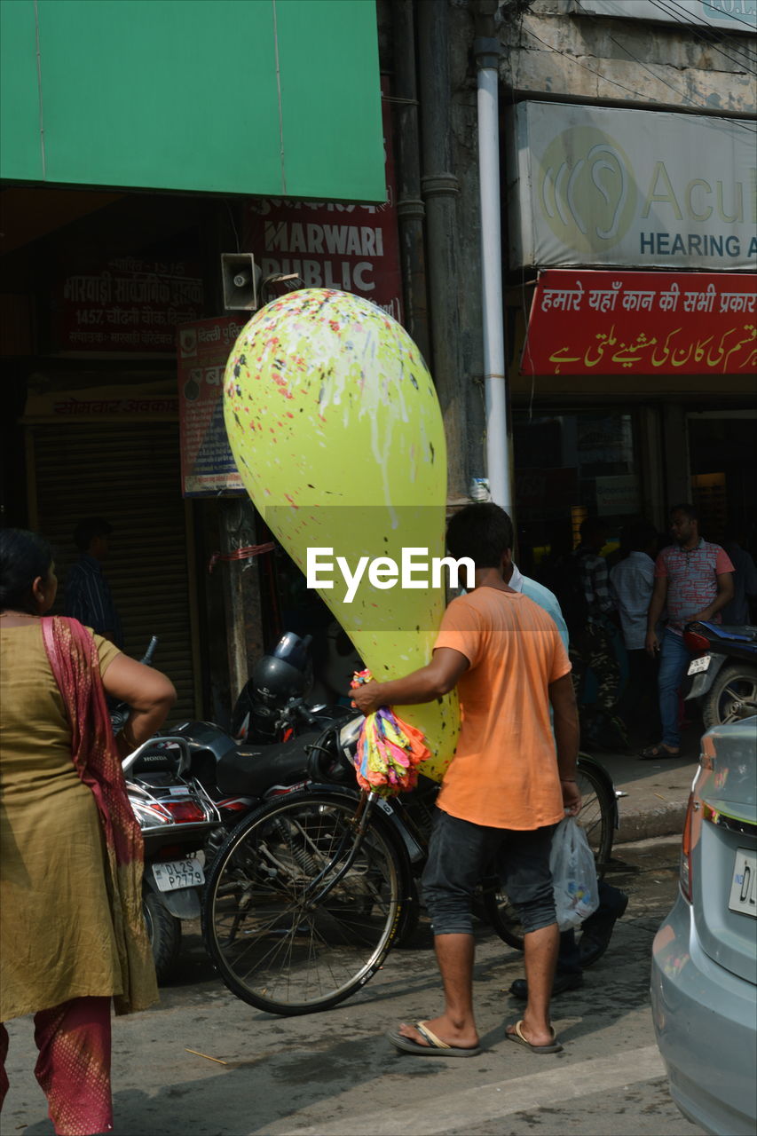 Rear view of people standing on street in city