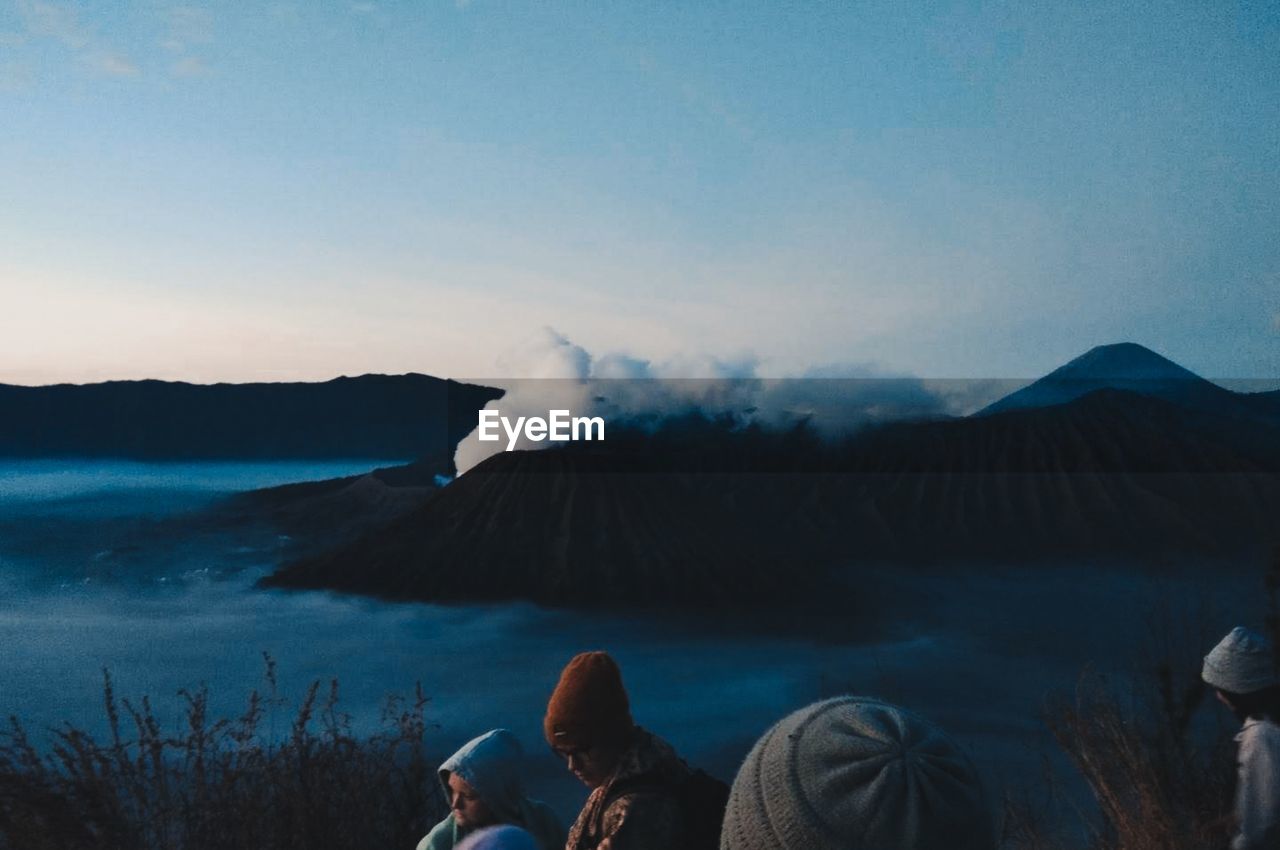 People on mountain against sky during dusk