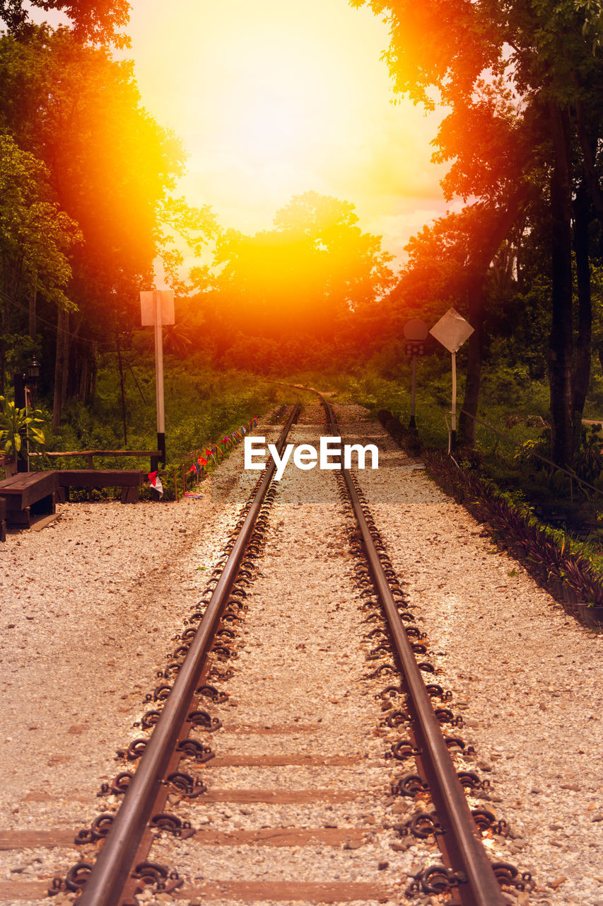 VIEW OF RAILROAD TRACKS AGAINST ORANGE SKY