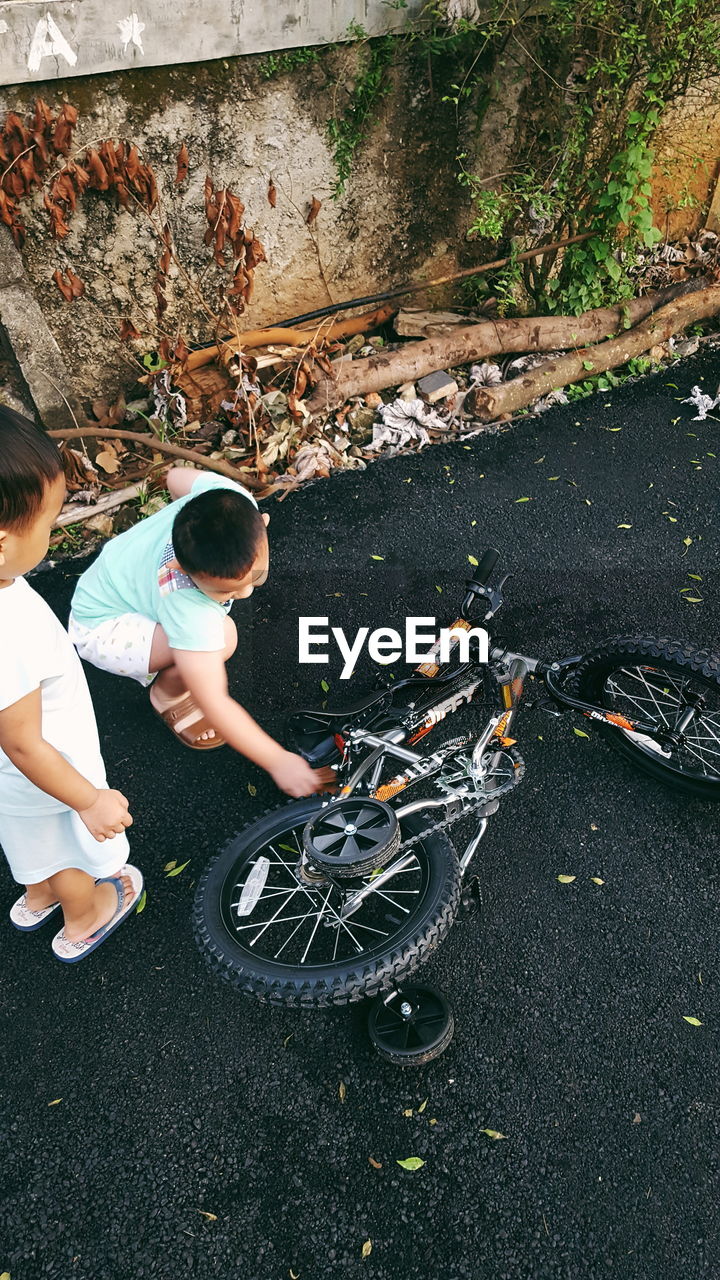 BOY WITH BICYCLE IN BACKGROUND