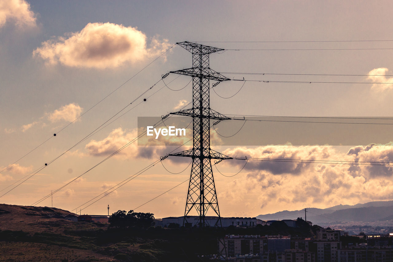 Low angle view of silhouette electricity pylon against sky during sunset