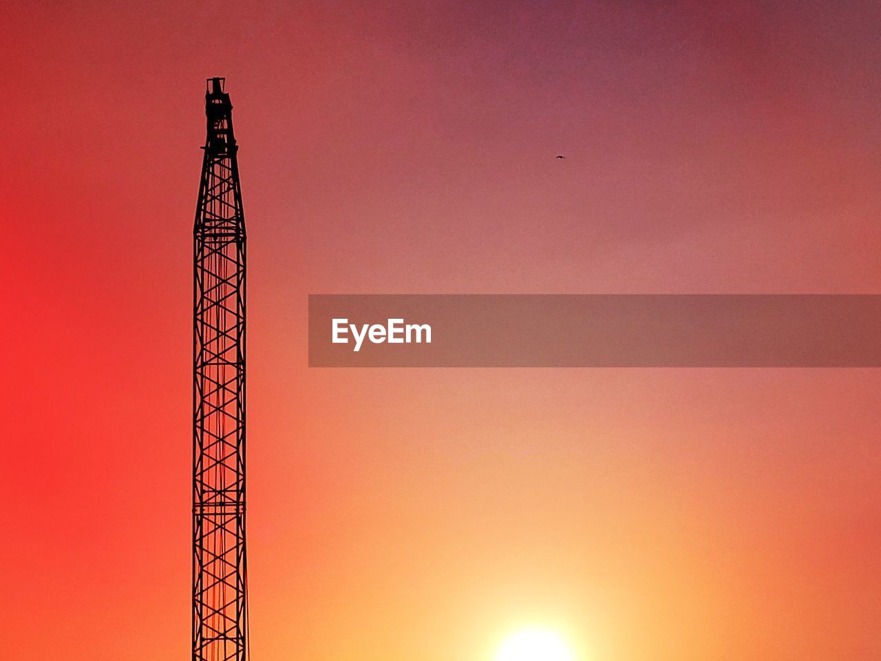 LOW ANGLE VIEW OF COMMUNICATIONS TOWER AGAINST DRAMATIC SKY