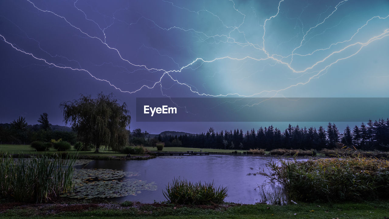 SCENIC VIEW OF LIGHTNING OVER LAKE AT NIGHT