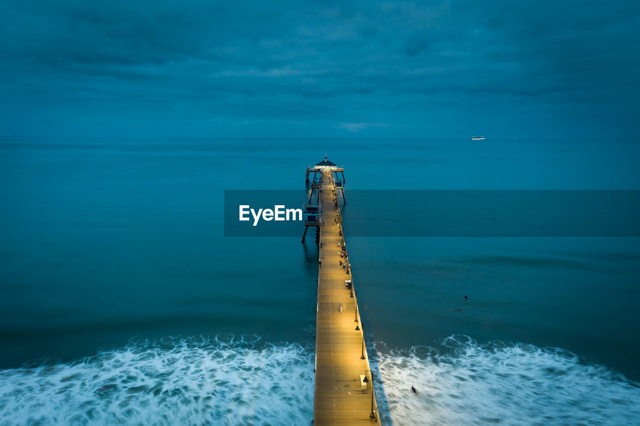 Drone view of imperial beach pier at dawn. boat lights in distance