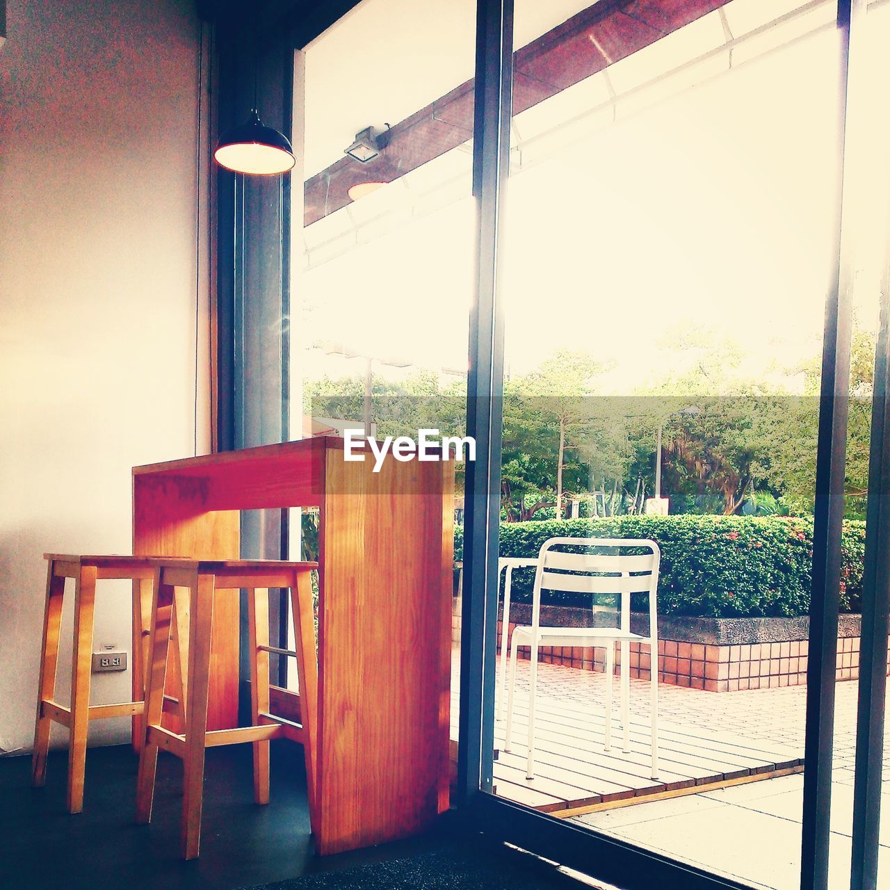 EMPTY CHAIRS AND TABLES BY WINDOW