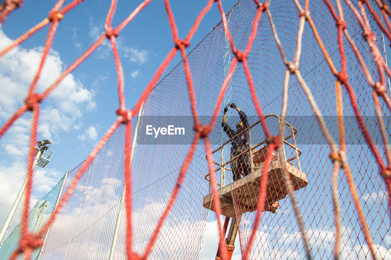 Low angle view of metal fence against sky