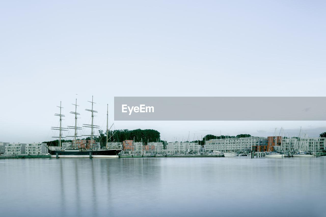 SAILBOATS IN RIVER AGAINST SKY