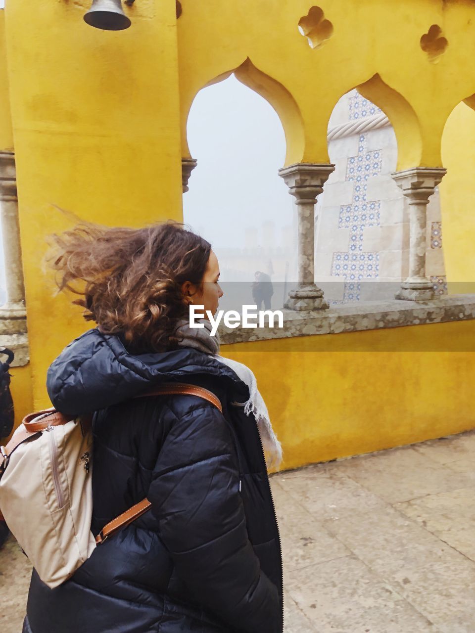 Teenage girl standing at historical building