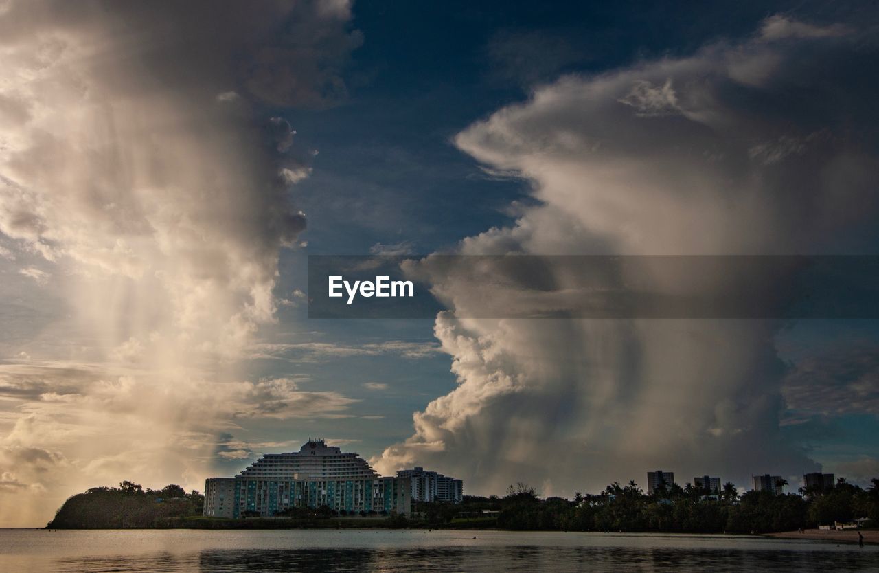 PANORAMIC VIEW OF BUILDINGS IN CITY AGAINST CLOUDY SKY