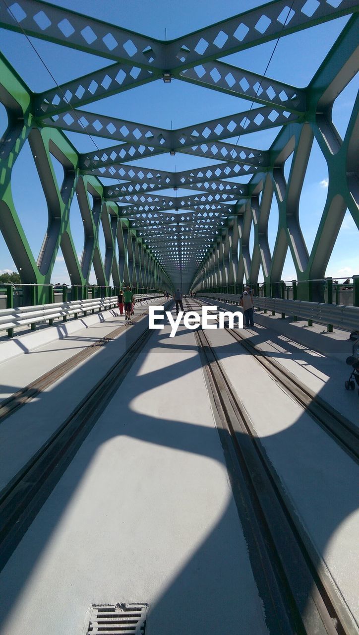 People on railway bridge during sunny day