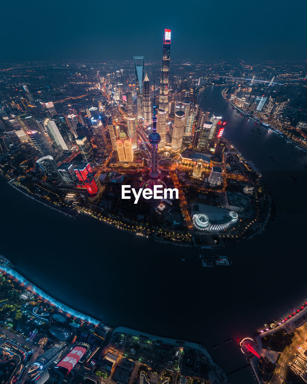 HIGH ANGLE VIEW OF ILLUMINATED CITY AGAINST SKY AT NIGHT