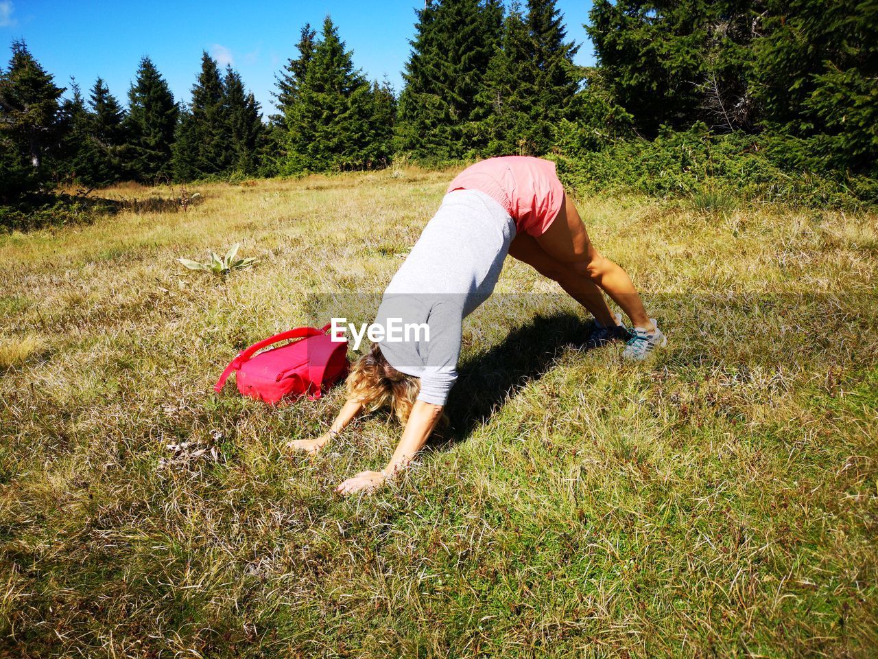 Full length of woman exercising on grassy field