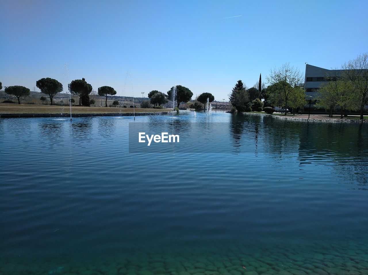 Scenic view of lake against clear blue sky