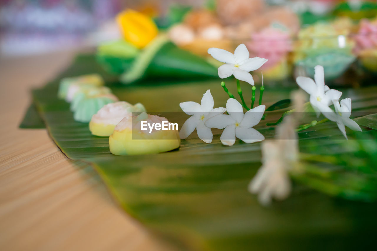 Close-up of dessert and flowers in banana leaf