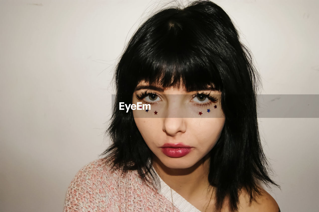 Close-up portrait of woman with make-up over white background