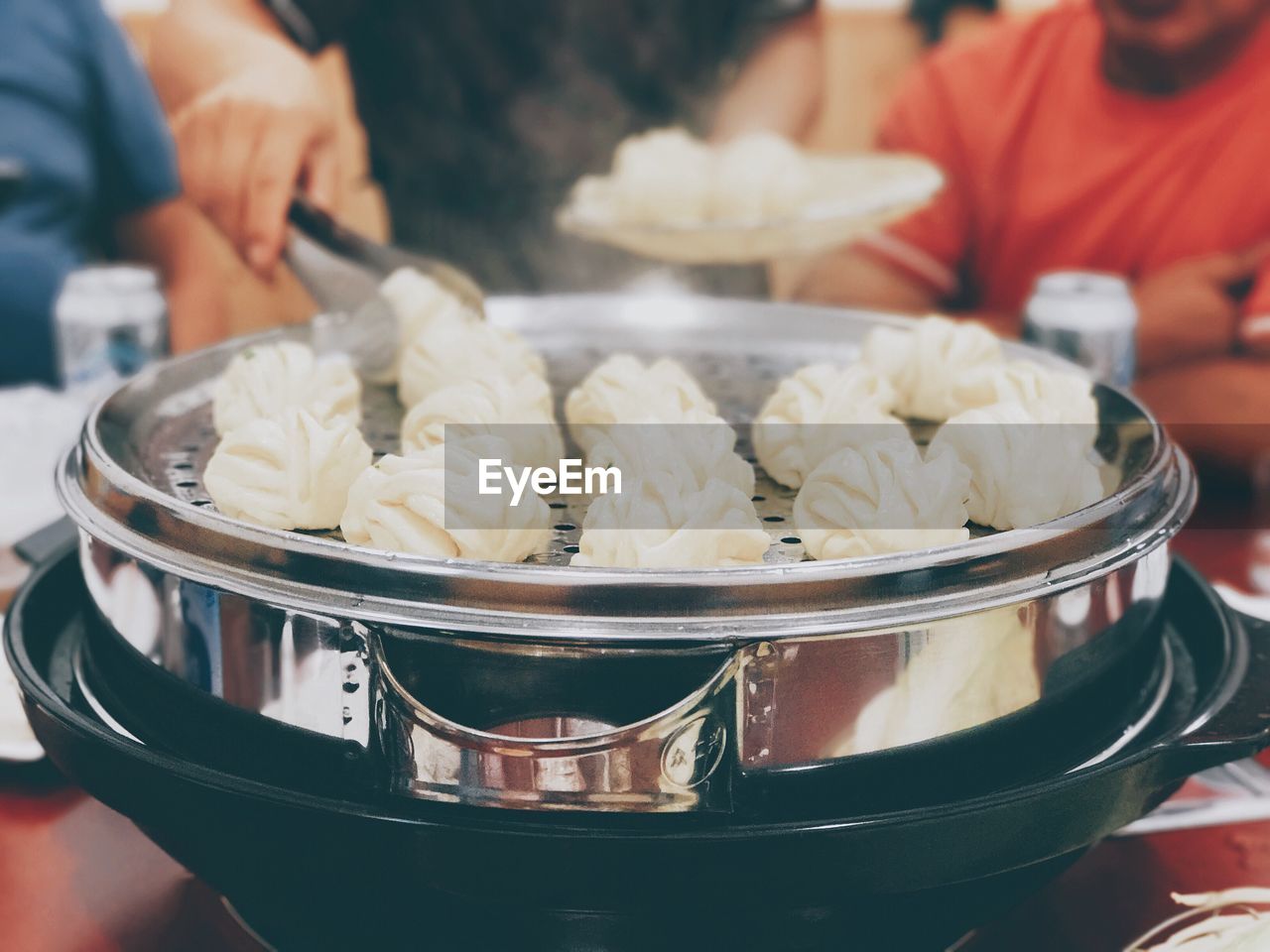 Close-up of man preparing steamed food in pot