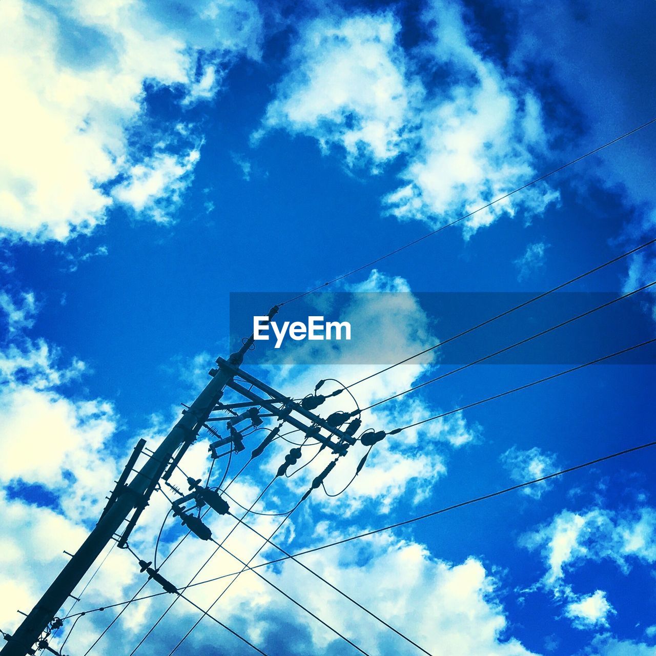 LOW ANGLE VIEW OF POWER LINES AGAINST BLUE SKY