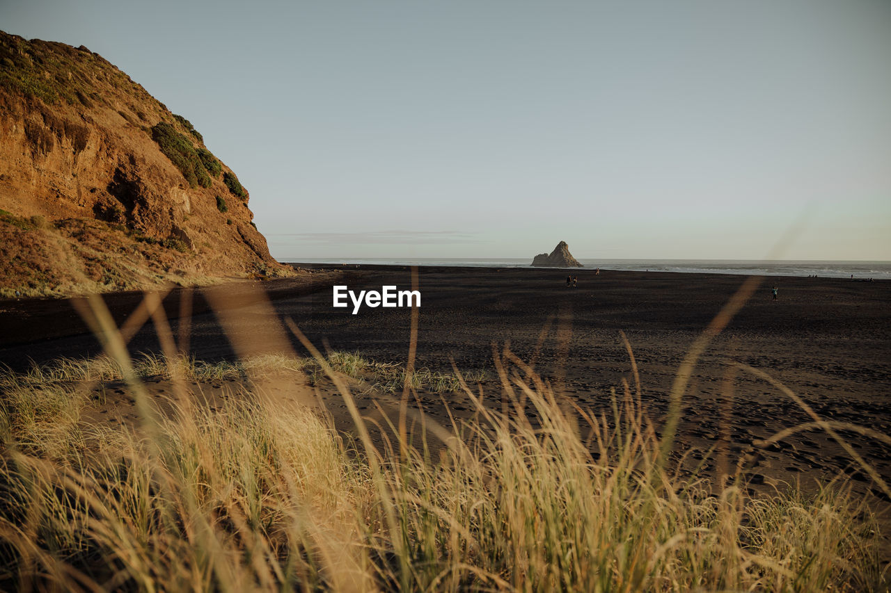 Scenic view of land and beach against clear sky