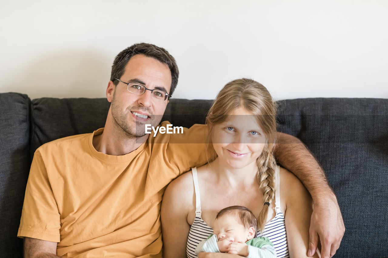 Portrait of smiling family sitting on sofa