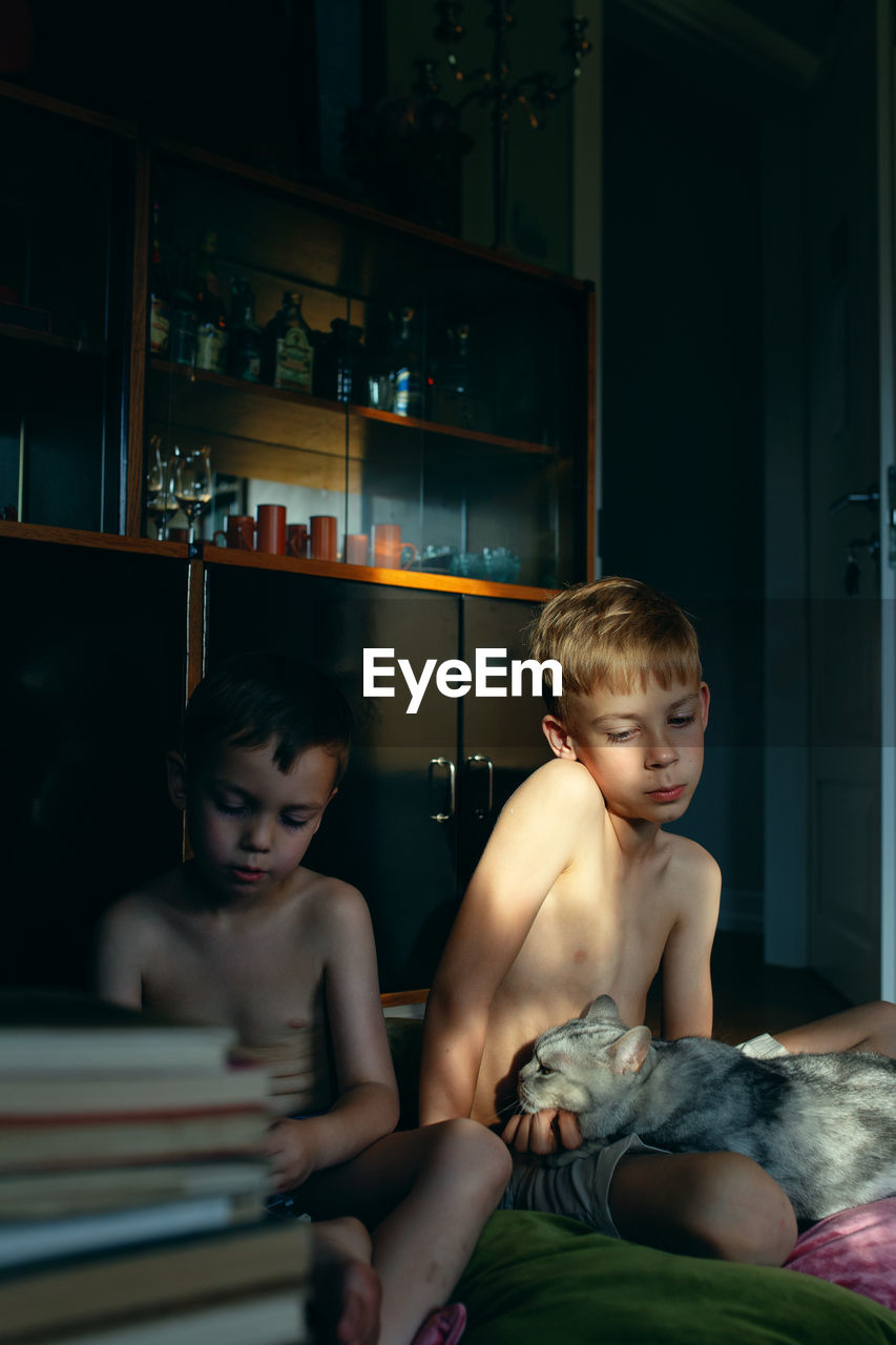 PORTRAIT OF BOY SITTING AT HOME