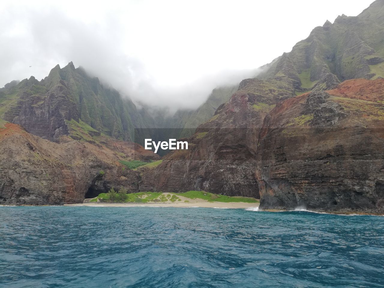 Scenic view of sea and mountains against sky