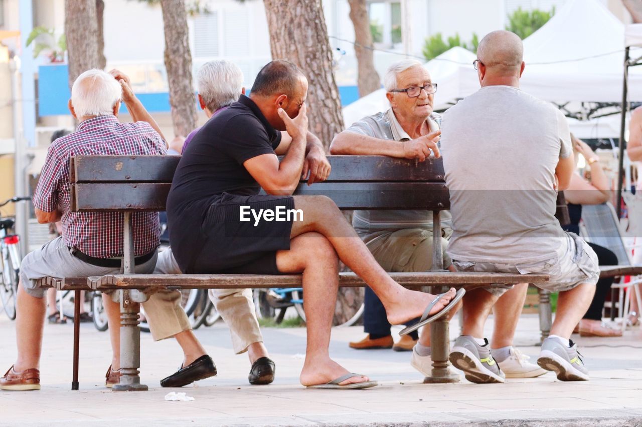 REAR VIEW OF PEOPLE SITTING ON TERRACE