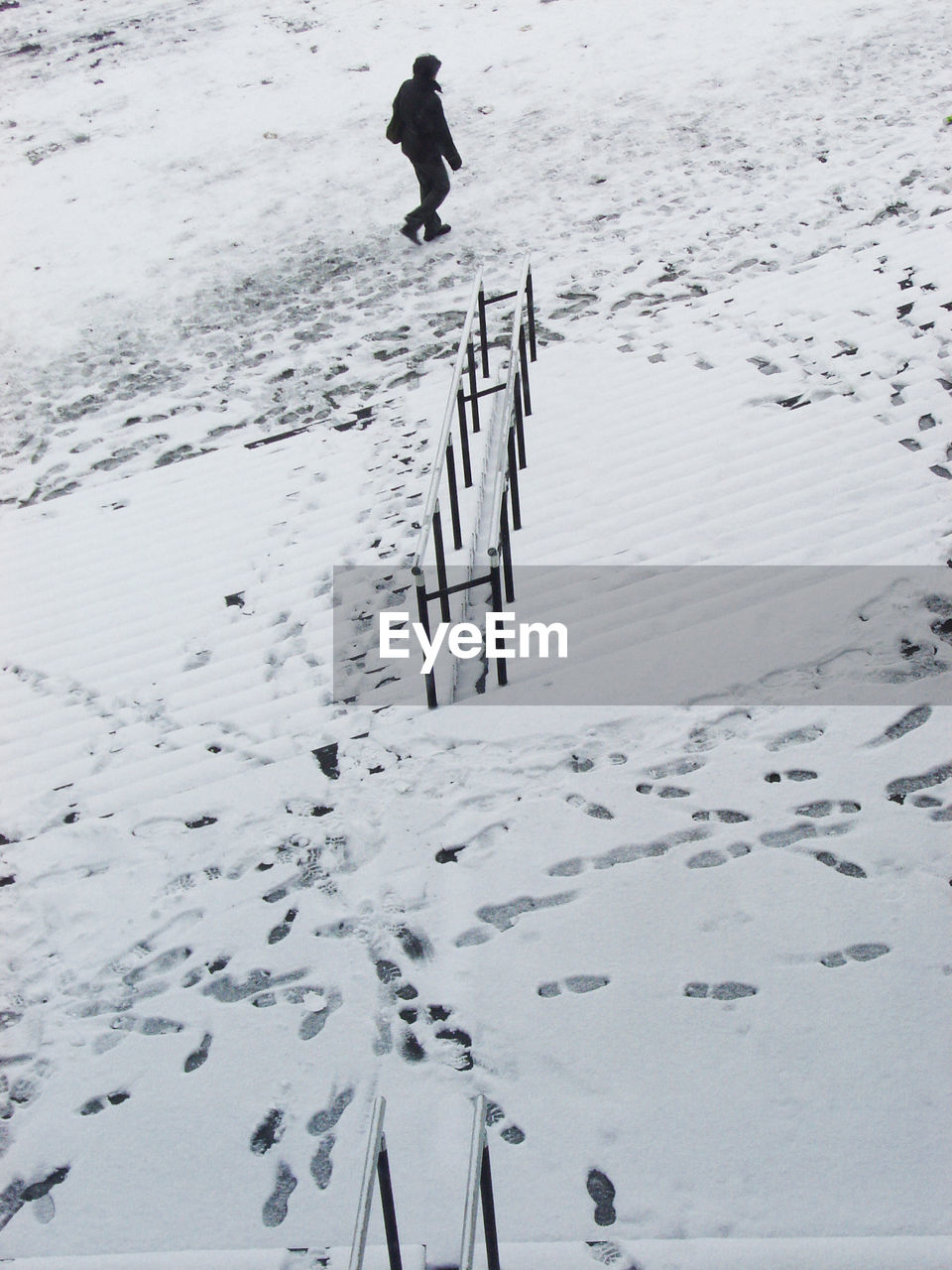 High angle view of person walking by snow covered steps