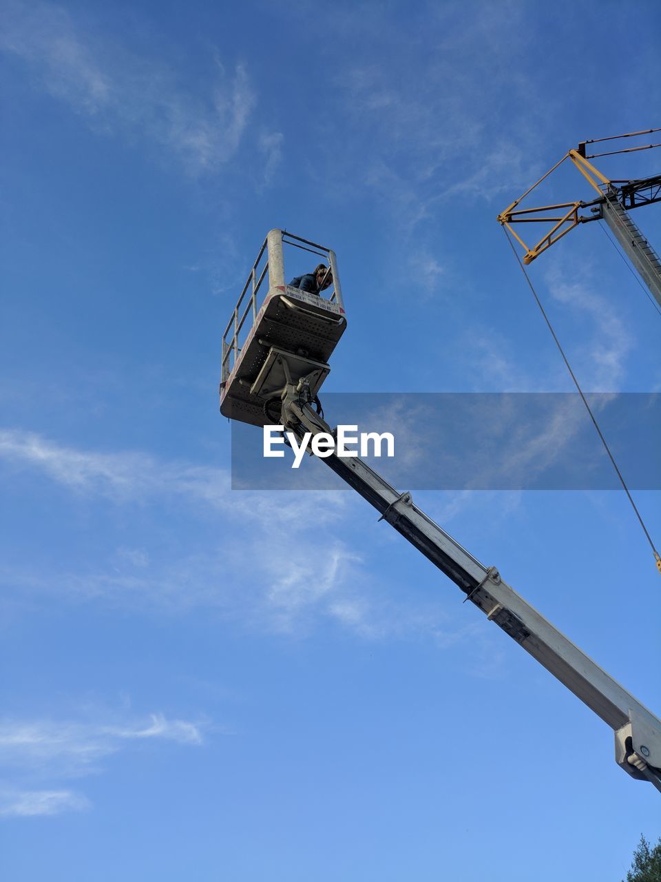 LOW ANGLE VIEW OF CRANE AT CONSTRUCTION SITE AGAINST SKY