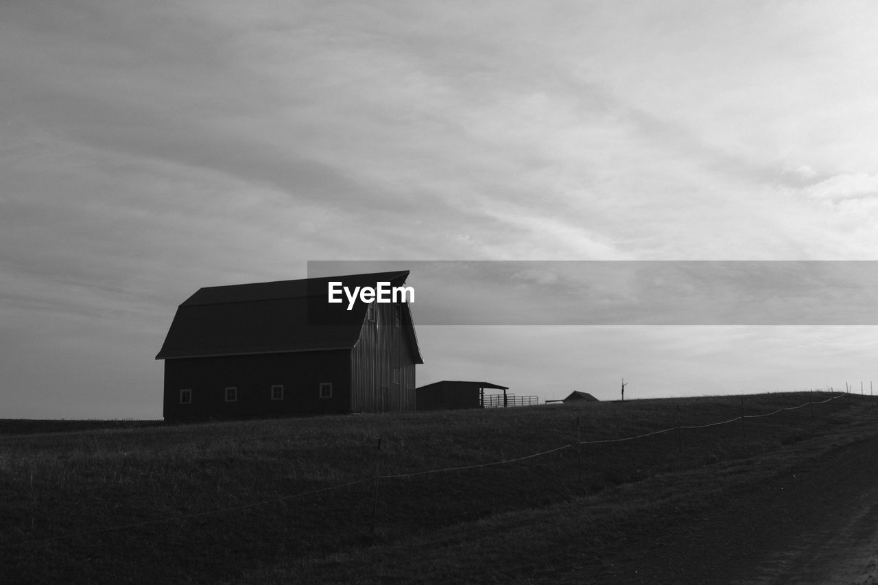 Barn on field against sky