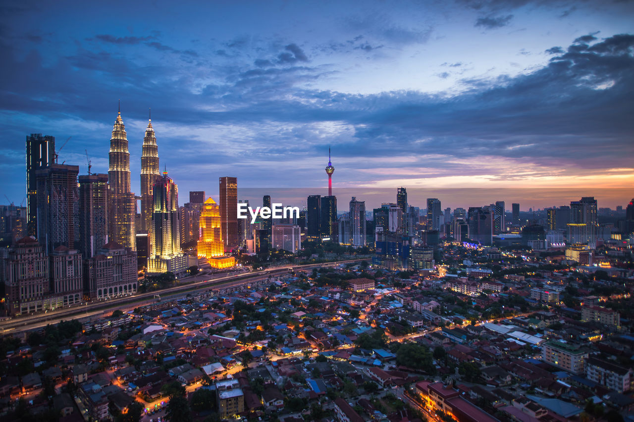 Illuminated modern buildings in city at dusk