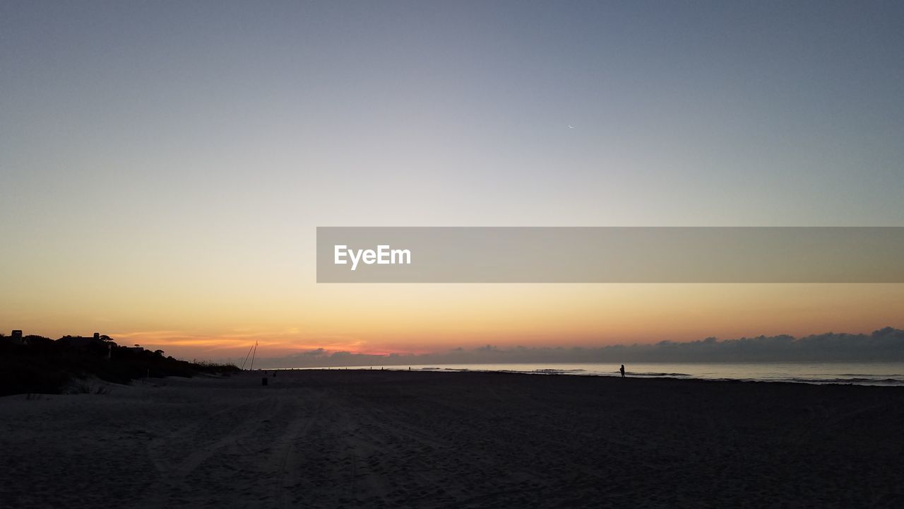 SCENIC VIEW OF SILHOUETTE FIELD AGAINST SKY DURING SUNSET